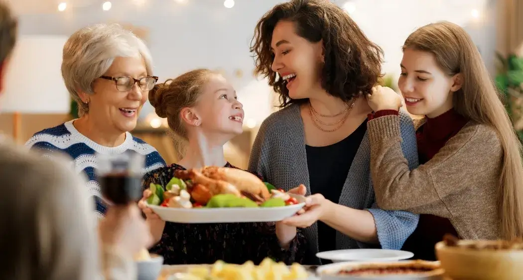 Family celebrating Thanksgiving dinner with smiles and warm atmosphere